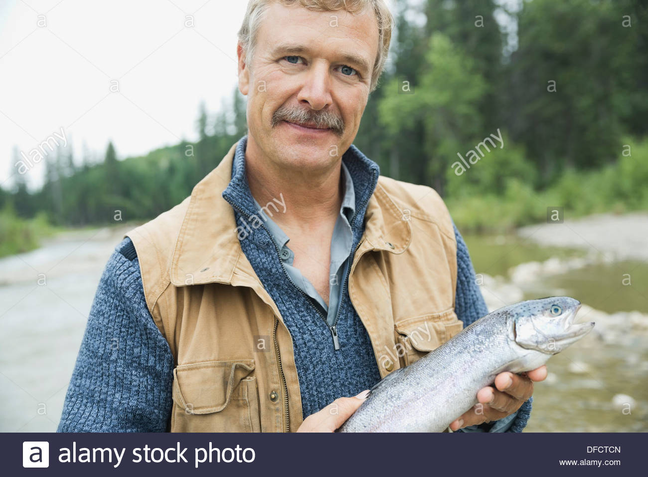 Ritratto di uomo maturo tenendo il pesce appena pescato Foto Stock