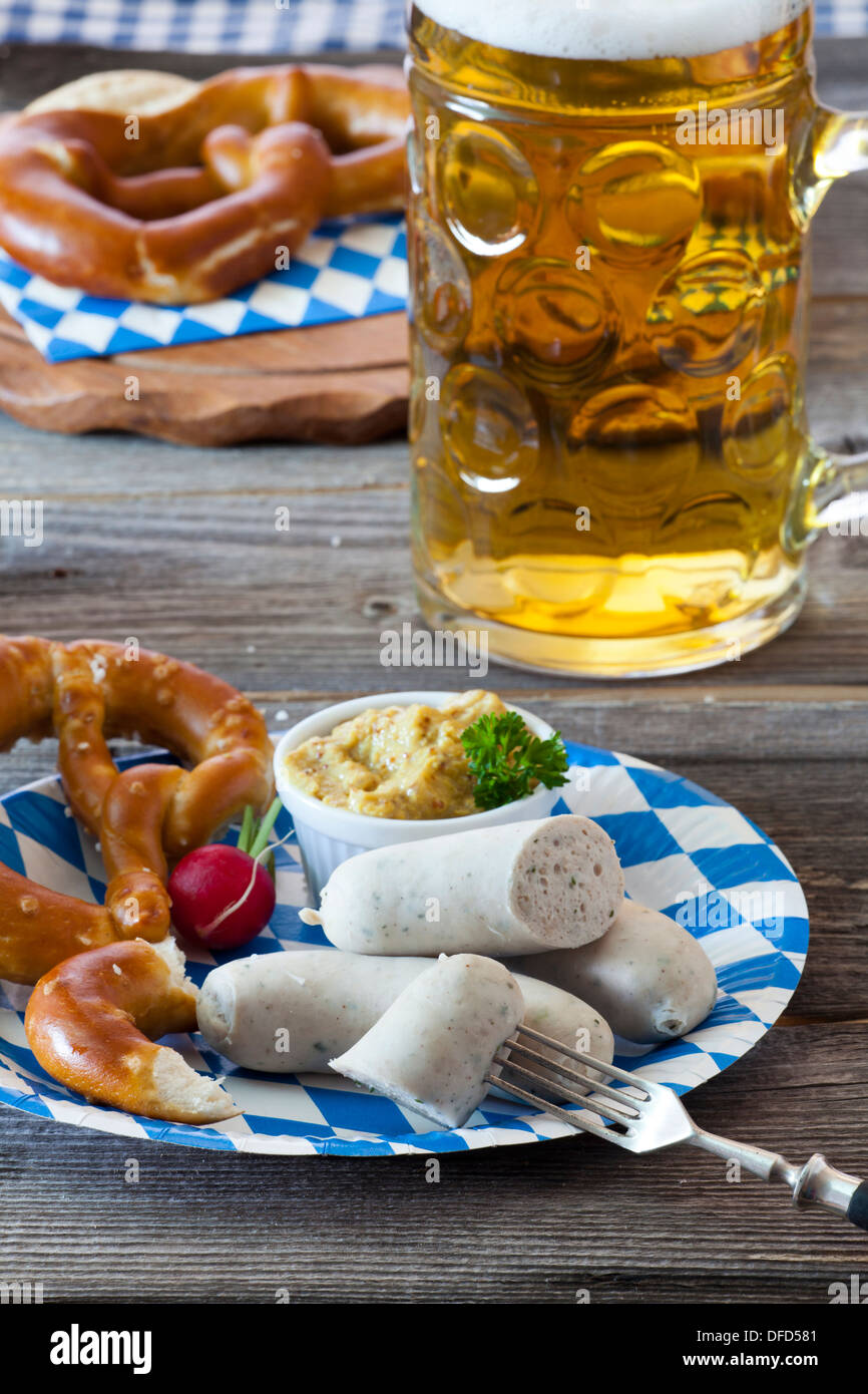 Oktoberfest pasto con salsiccia di vitello, senape, salatini e una birra fredda su una tavola in legno rustico Foto Stock