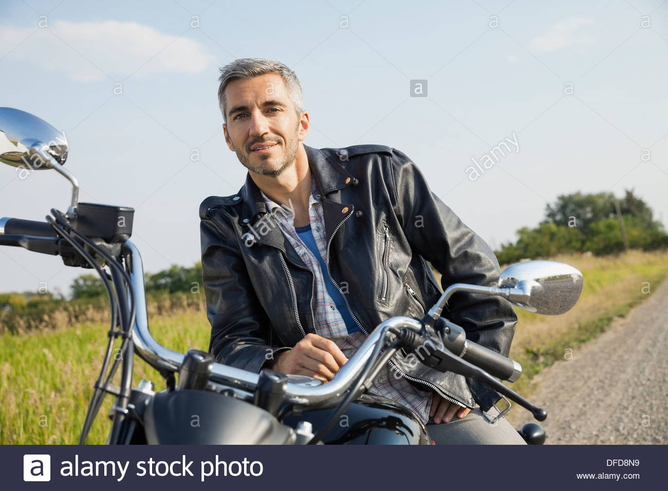 Ritratto di fiducioso biker seduto sul motociclo Foto Stock