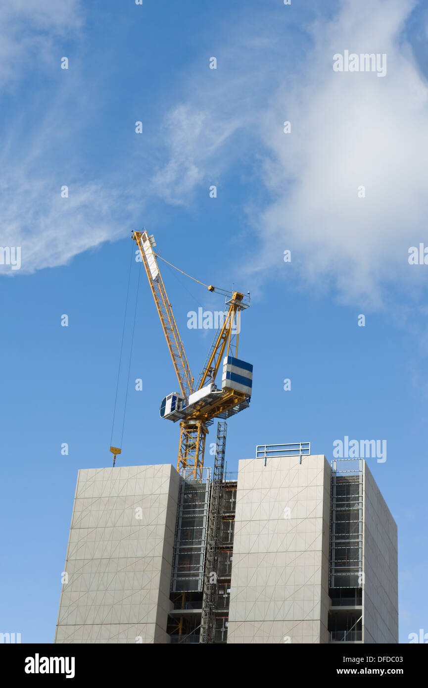 Gru da cantiere e edificio in costruzione contro il cielo blu Foto Stock