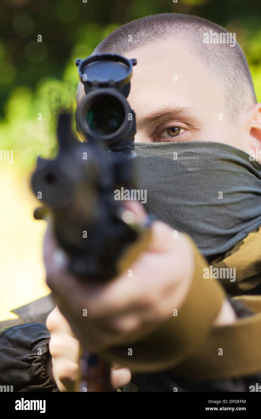 Soldato in camuffamento con un kalashnikov fucile da assalto, riprese nel bosco Foto Stock