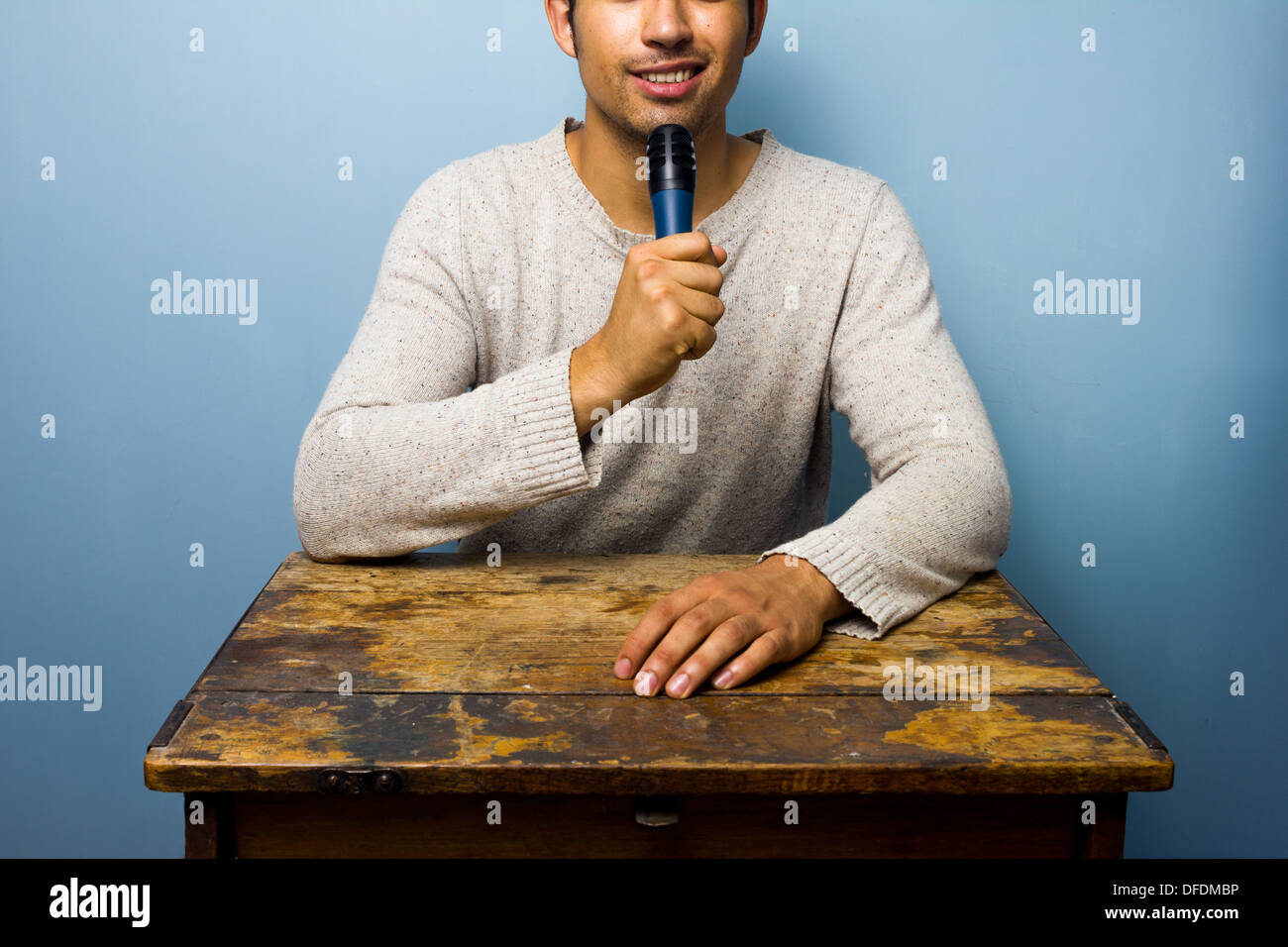 Giovane uomo alla scrivania si parla nel microfono Foto stock - Alamy