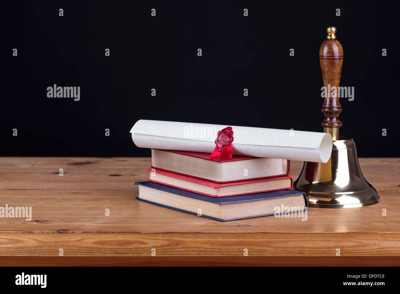 Banco di scuola con libri, Campana e un certificato contro uno sfondo nero, aggiungi il proprio testo. Foto Stock