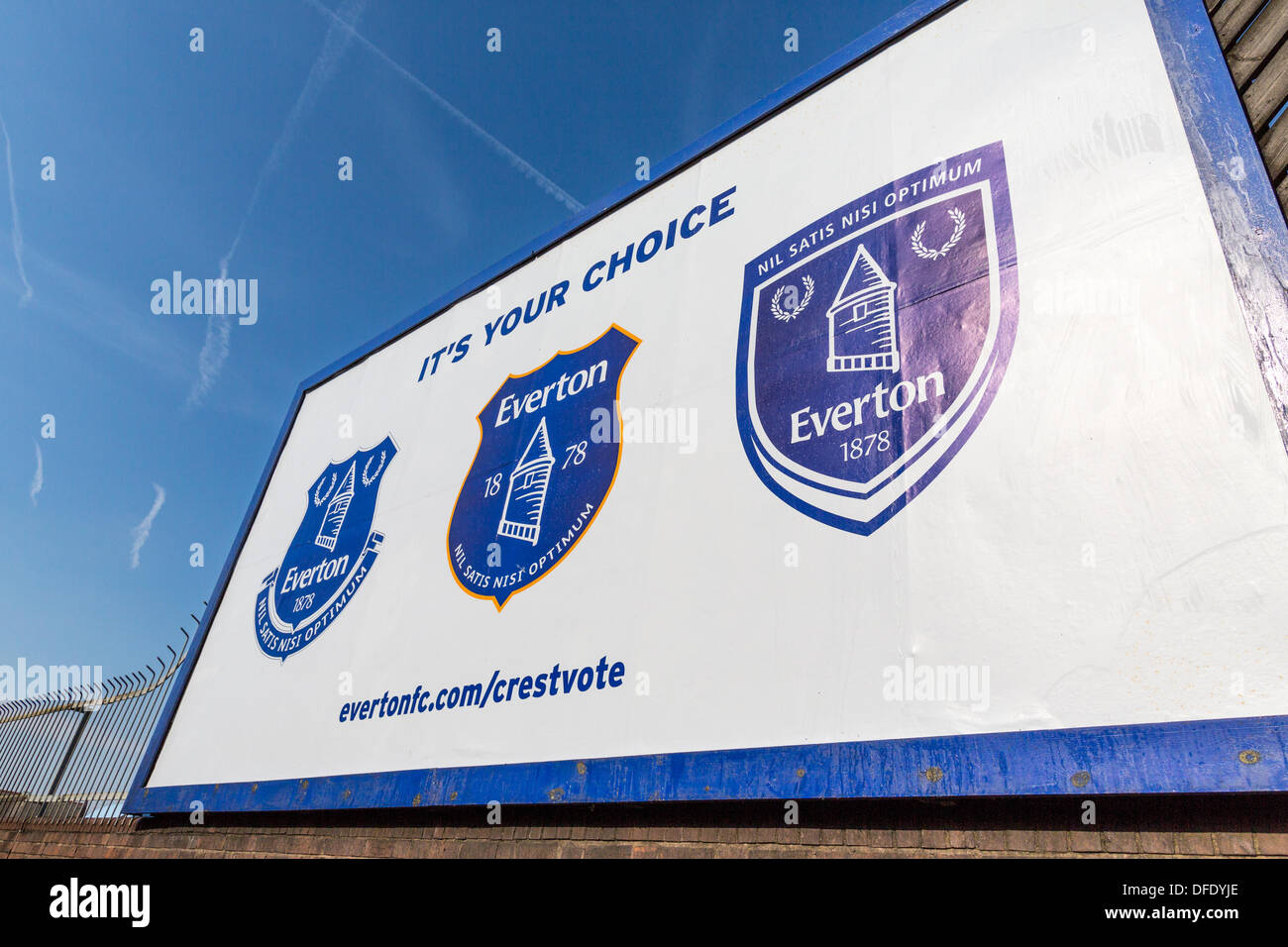 Una palizzata al di fuori di Goodison Park di Liverpool che mostra le tre opzioni di cresta per Everton FC. La nuova cresta è sulla sinistra. Foto Stock