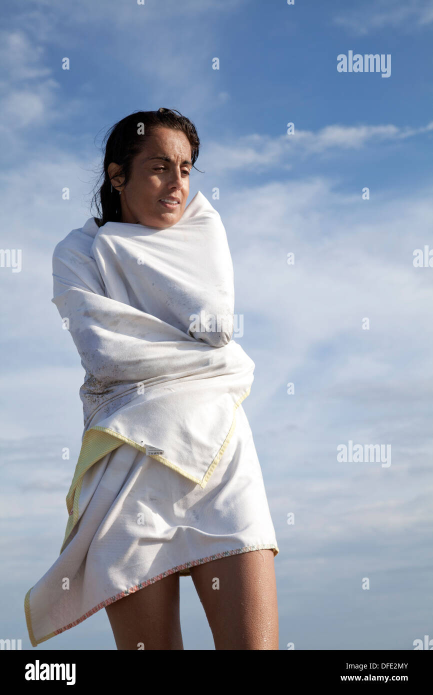 Wet donna avvolta in gli asciugamani per la spiaggia Foto Stock