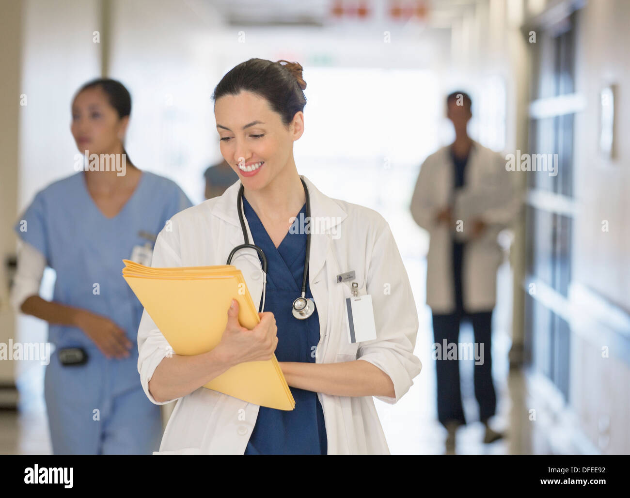 Medico guardando verso il basso in corrispondenza di file in corridoio ospedale Foto Stock