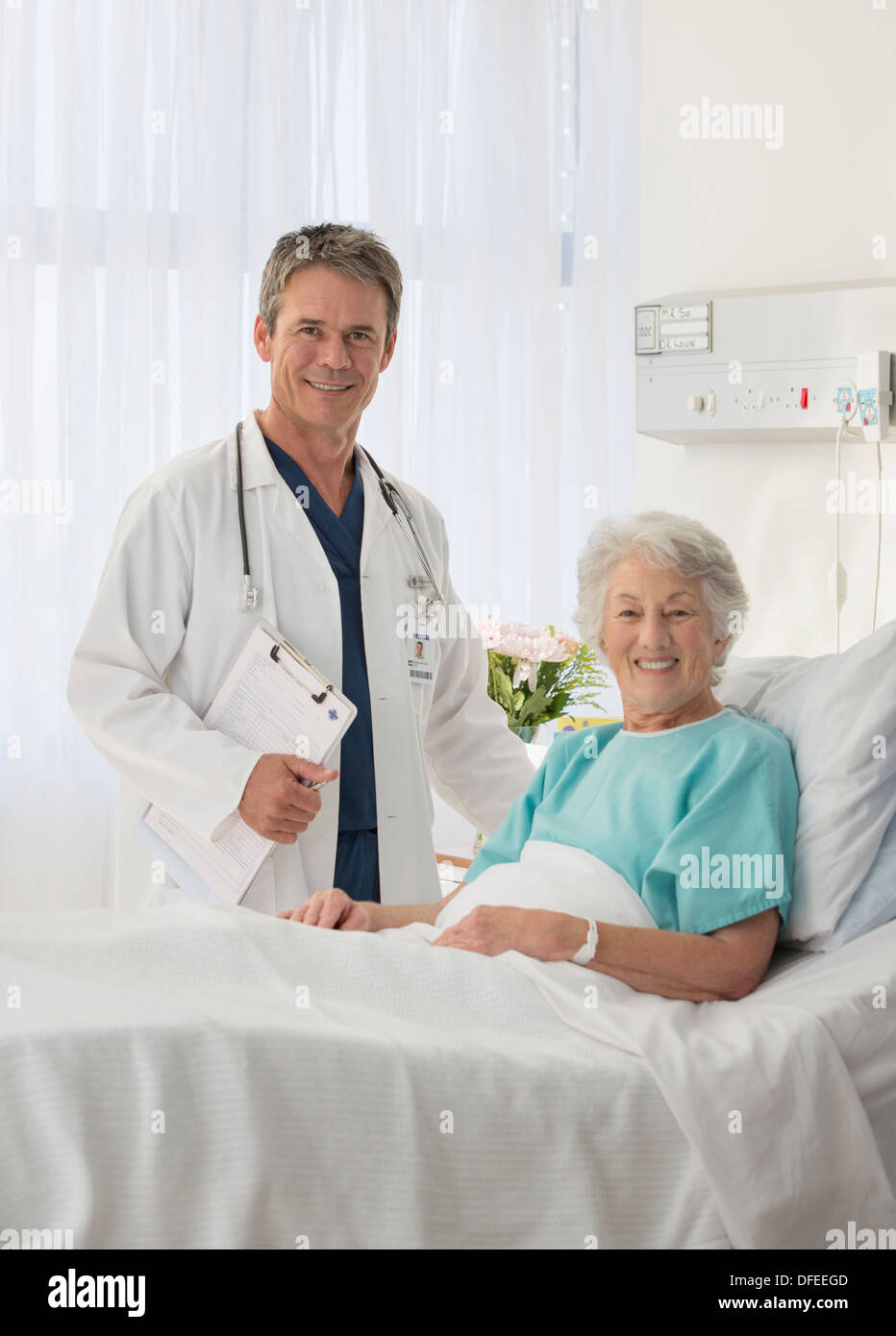 Ritratto di sorridere medico e paziente senior nella stanza di ospedale Foto Stock