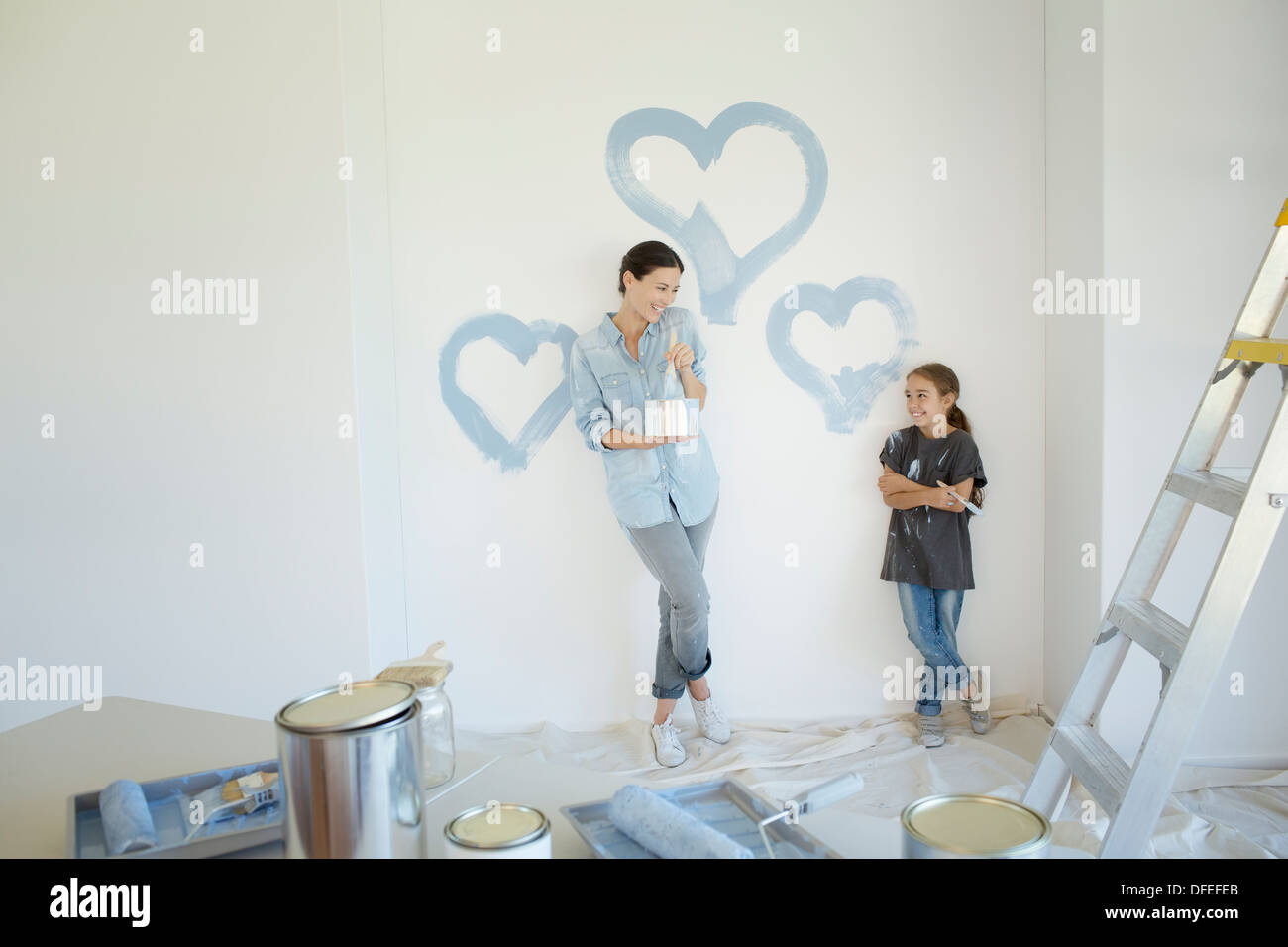 Madre e figlia di pittura cuori blu sulla parete Foto Stock
