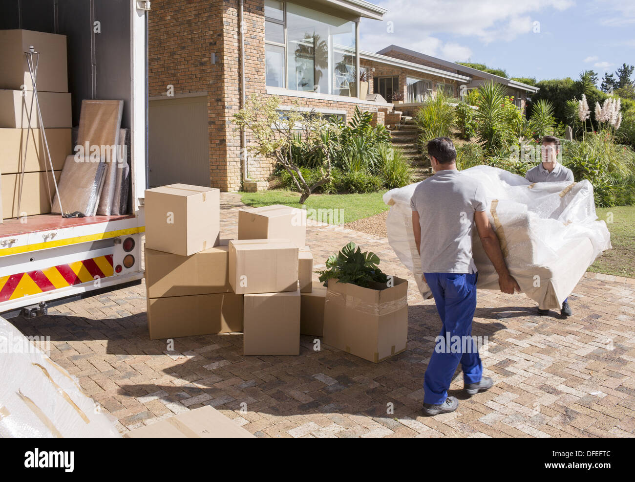 Movers trasportare divano dal movimento van a casa Foto Stock