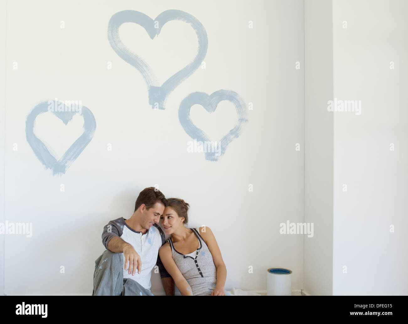 Giovane pittura cuori blu sulla parete Foto Stock