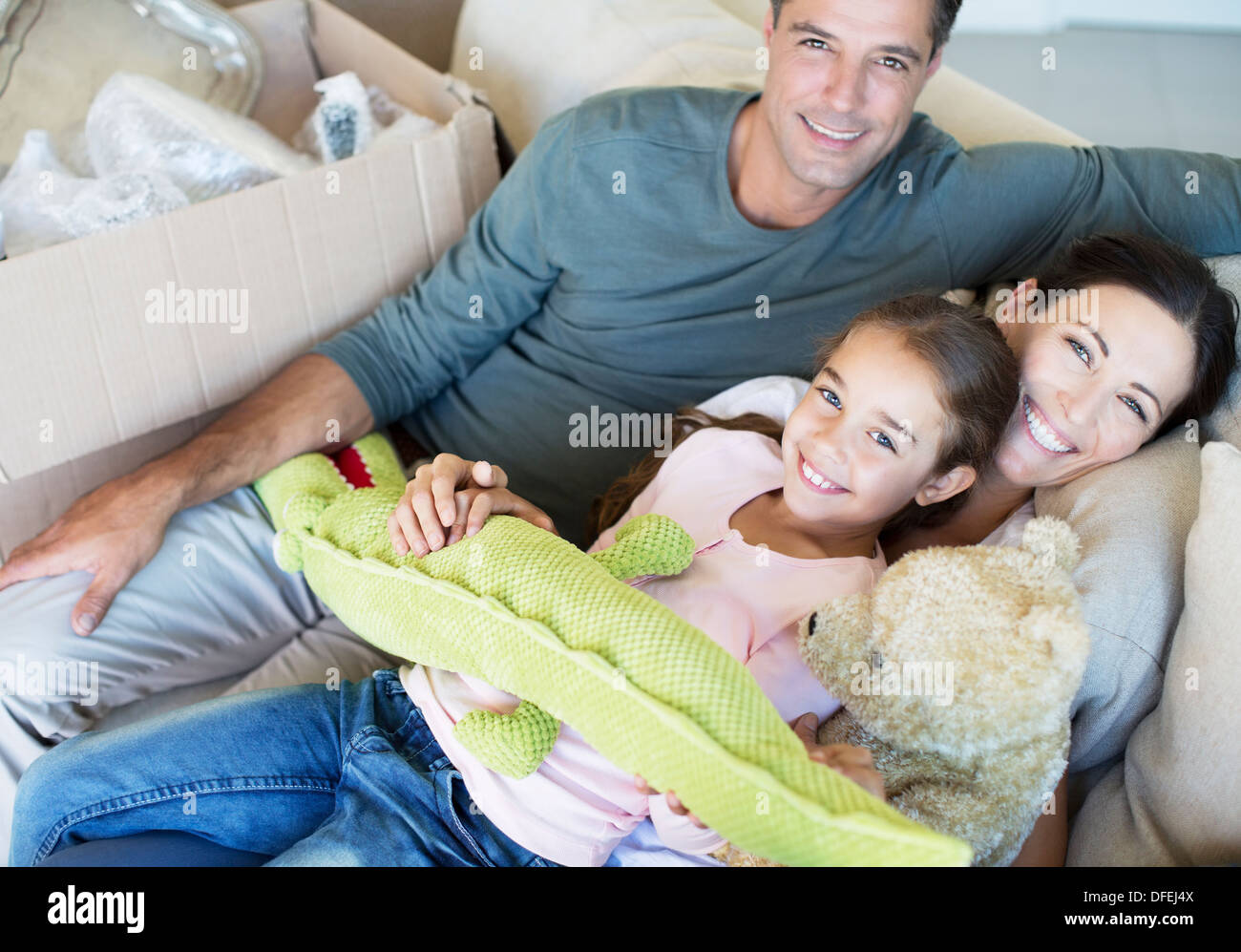 Ritratto di famiglia sorridente con animali imbalsamati sul divano Foto Stock