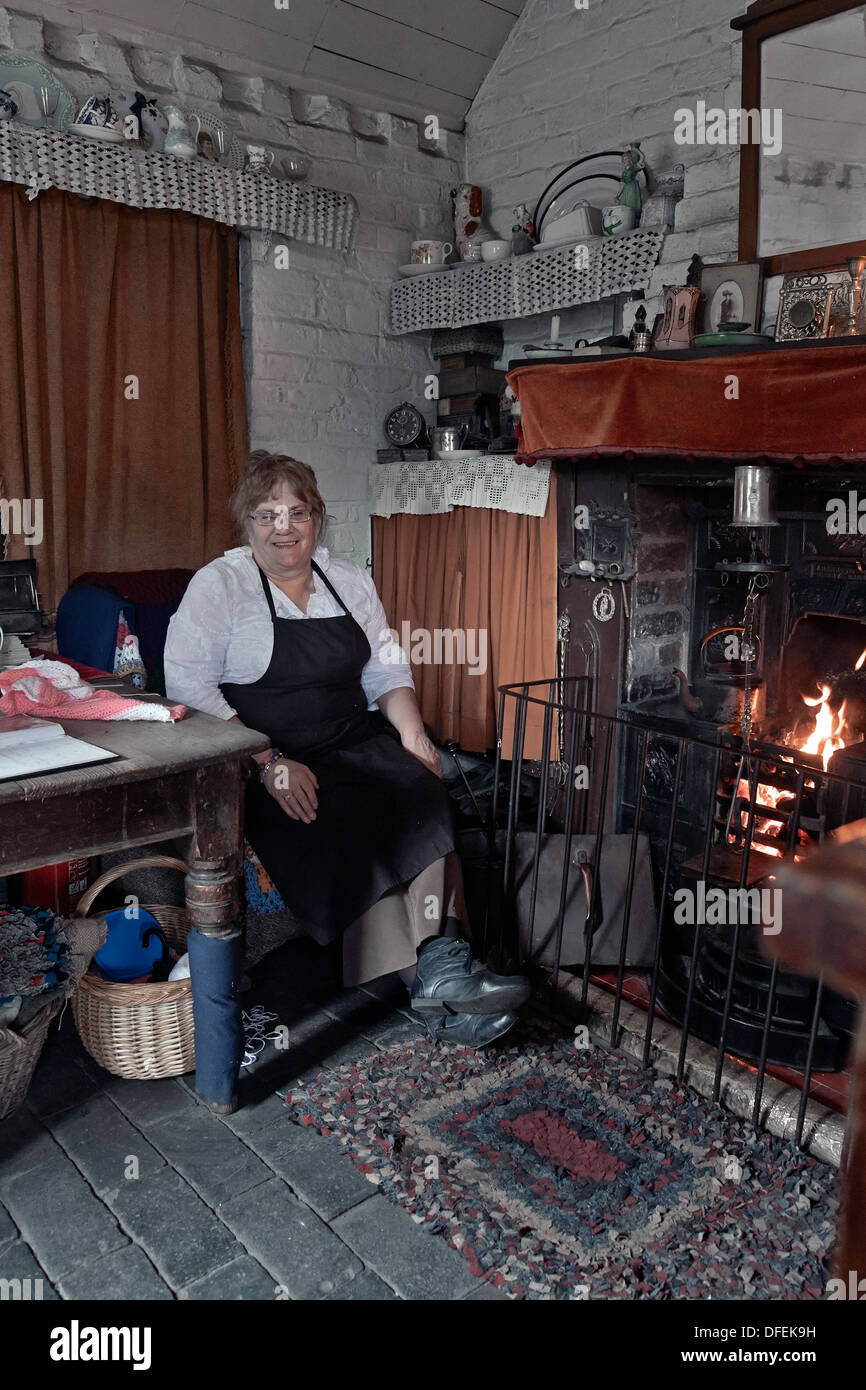 Donna dipendente del Black Country Living Museum accoglie i visitatori in una casa di tipo cottage del 1800/inizio del 1900. Camera di epoca vittoriana Inghilterra Foto Stock