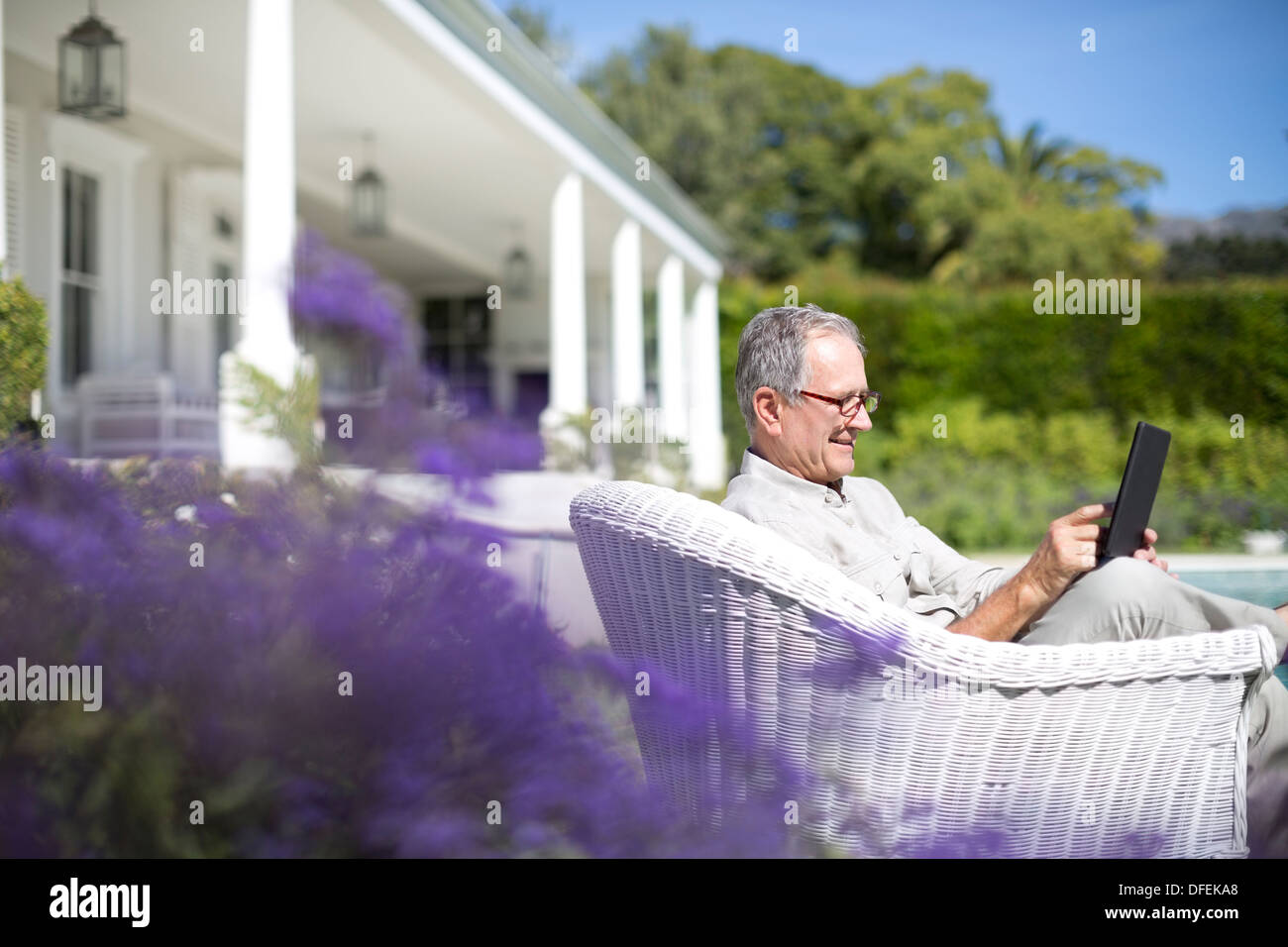 Senior uomo con tavoletta digitale in giardino Foto Stock