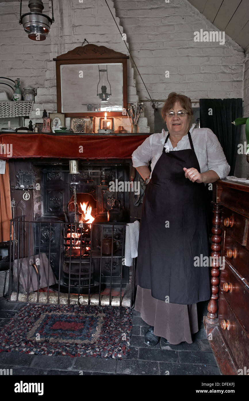 Donna dipendente del Black Country Living Museum accoglie i visitatori in una casa di tipo cottage del 1800/inizio del 1900. Camera di epoca vittoriana Inghilterra Foto Stock