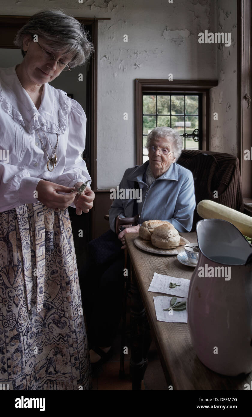 Donna dipendente del Black Country Living Museum che mostra ad un visitatore anziano gli articoli alimentari tradizionali dell'epoca del 1800/inizio del 1900. Inghilterra Regno Unito Foto Stock