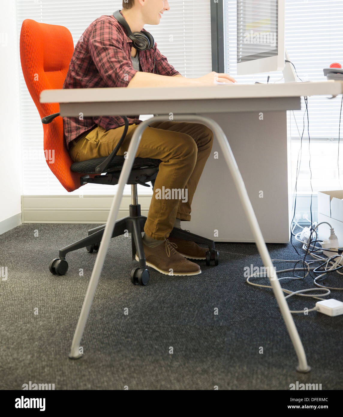 Imprenditore utilizzando computer presso la scrivania in ufficio Foto Stock