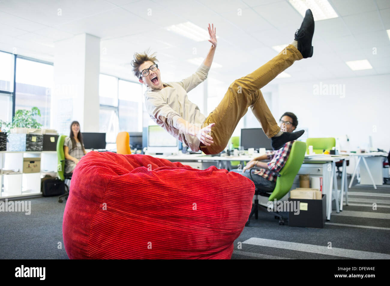 Imprenditore il salto in beanbag chair in ufficio Foto Stock