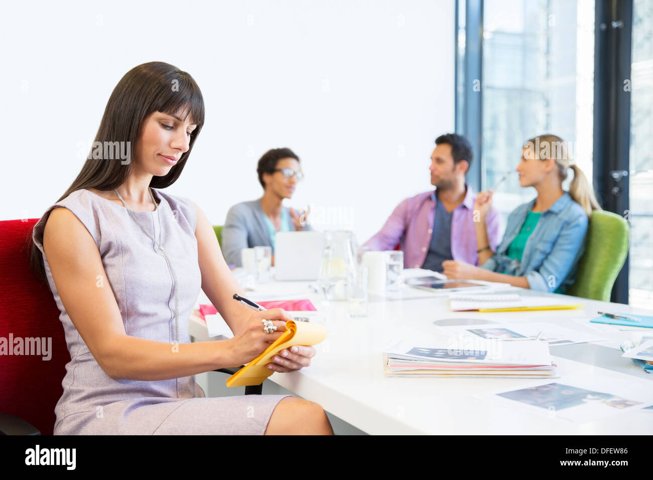 Imprenditrice prendendo appunti in riunione Foto Stock