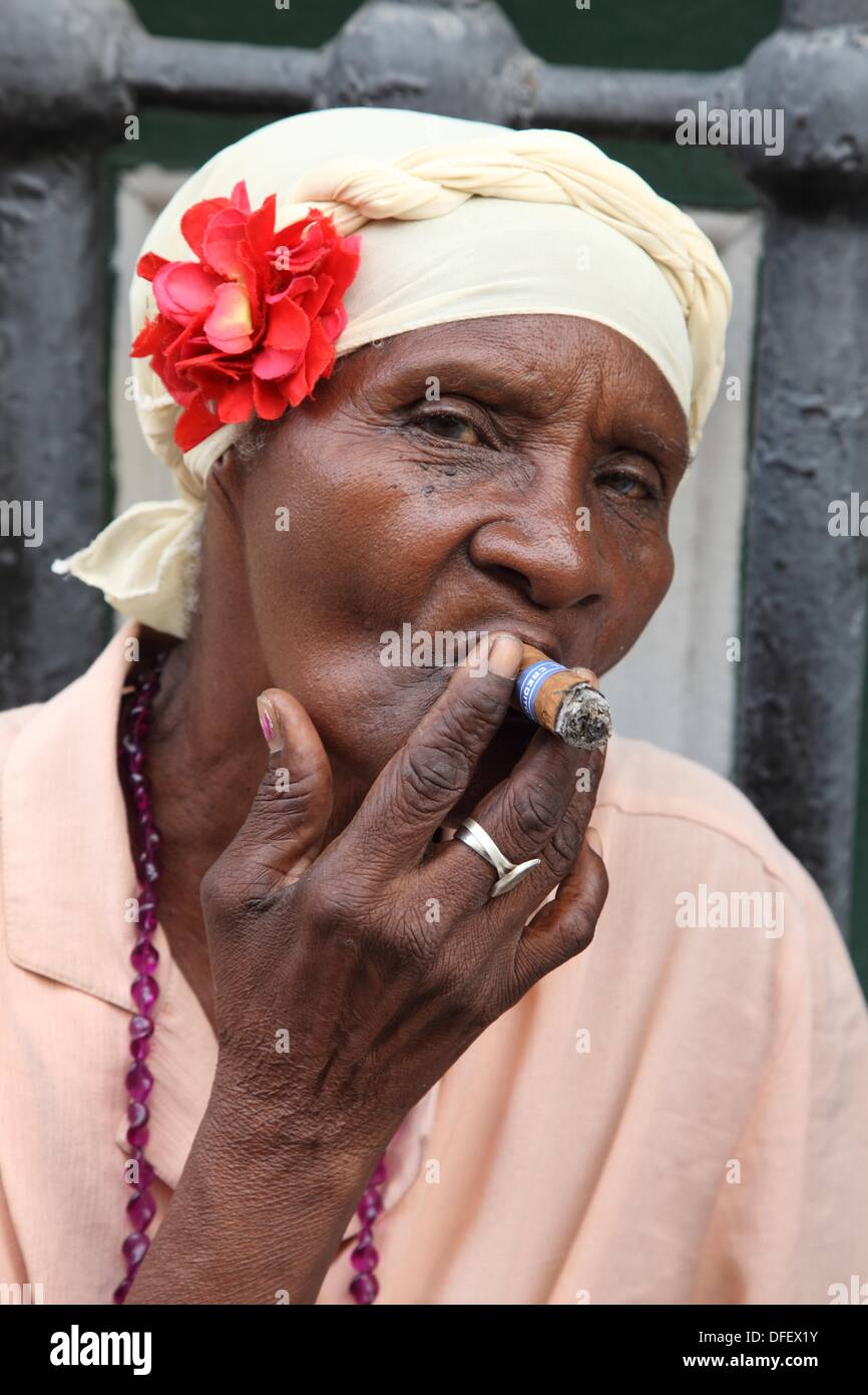 Morena donna fumatori di sigaro donna nera rappresentante per il tipico  Cubano del tempo nella Vecchia Havana, Cuba Foto stock - Alamy