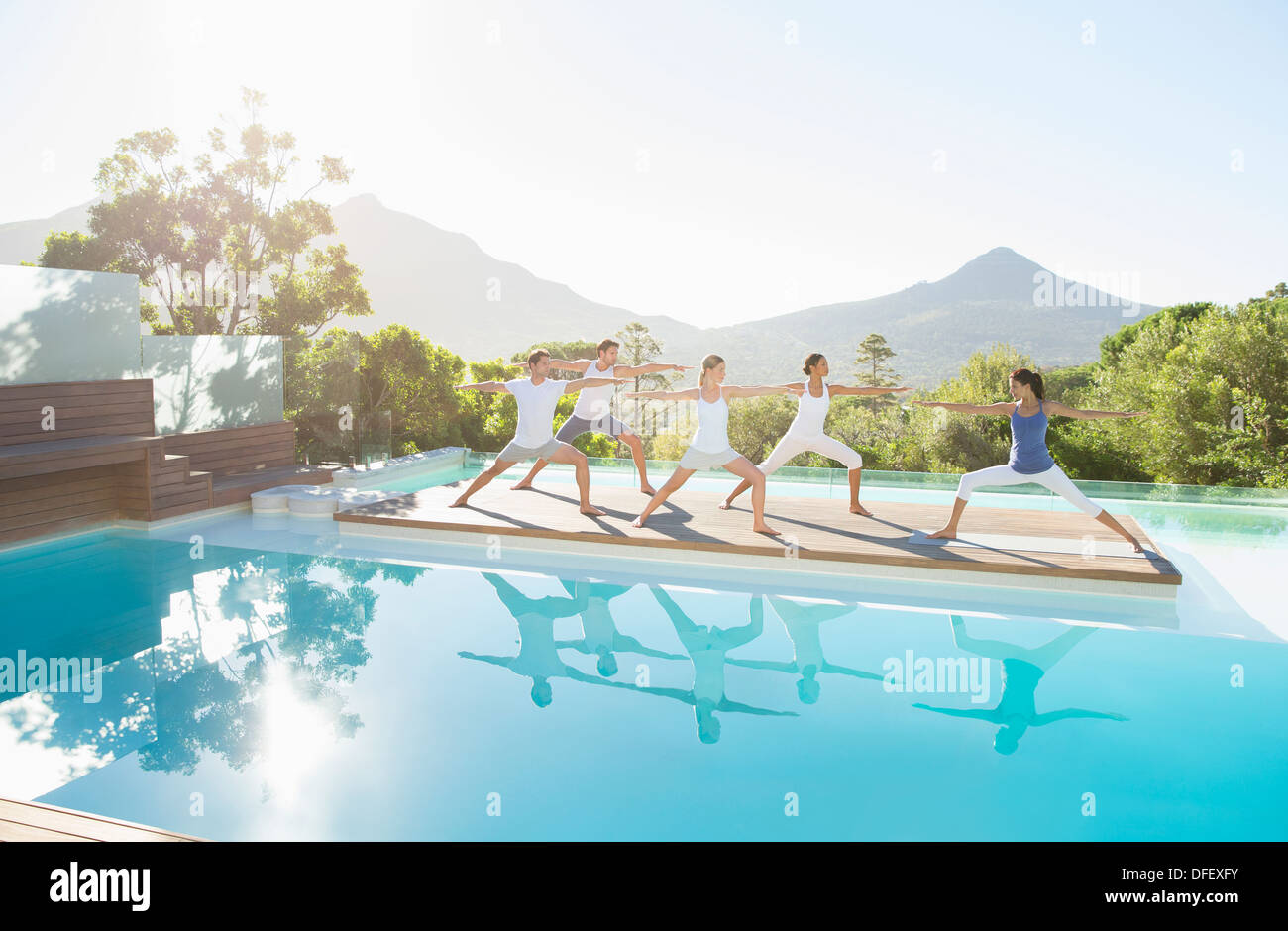 Persone che praticano lo Yoga a bordo piscina Foto Stock