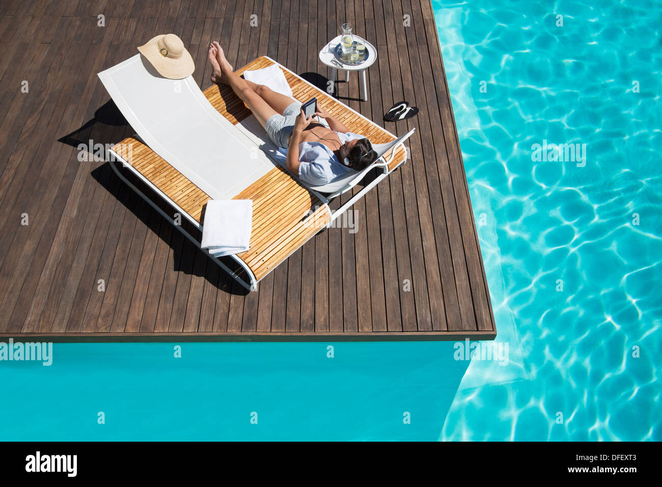 L'uomo rilassante sulla sedia a sdraio a bordo piscina Foto Stock