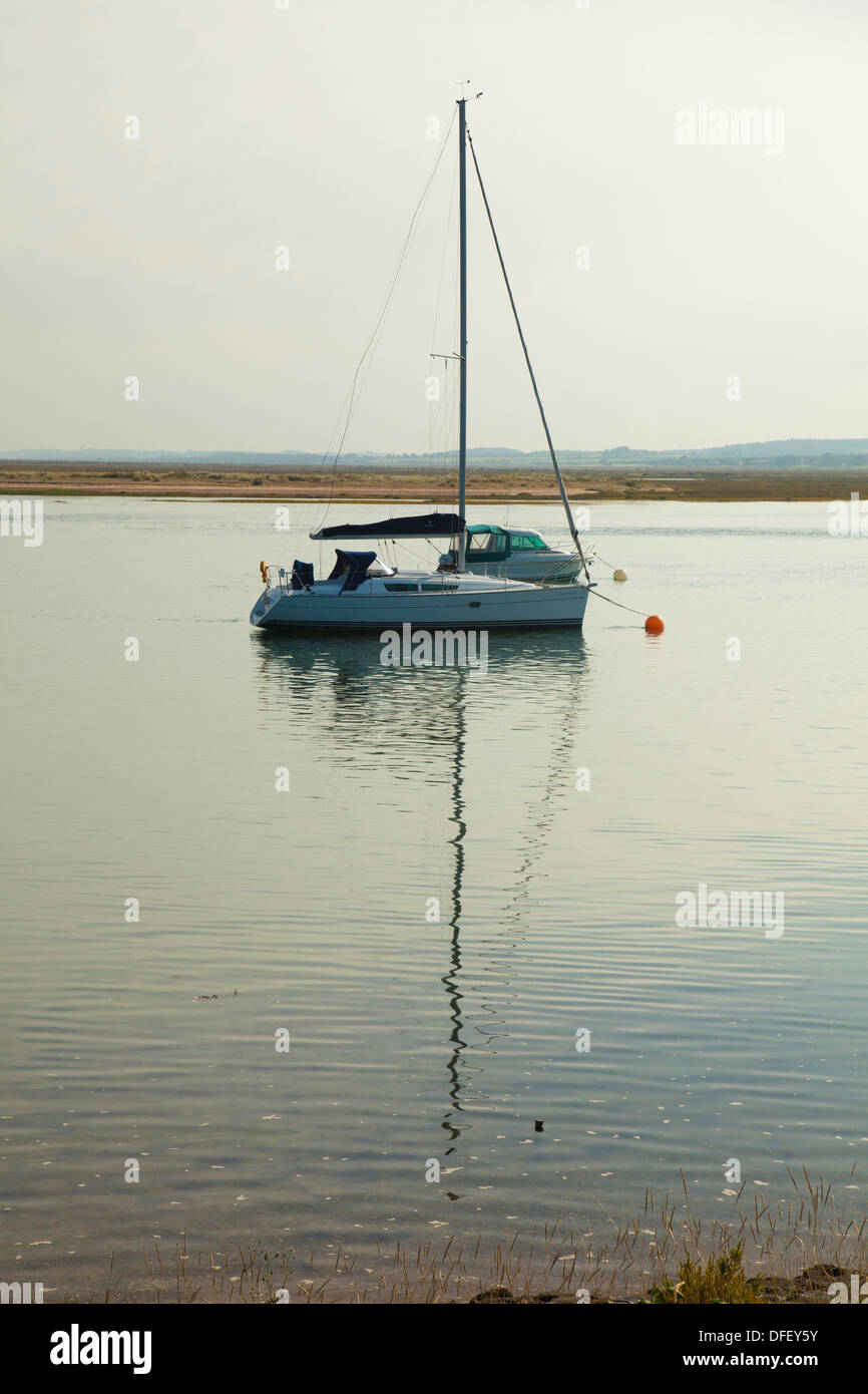 Yacht con la riflessione in estuario a Wells accanto il mare Norfolk Foto Stock