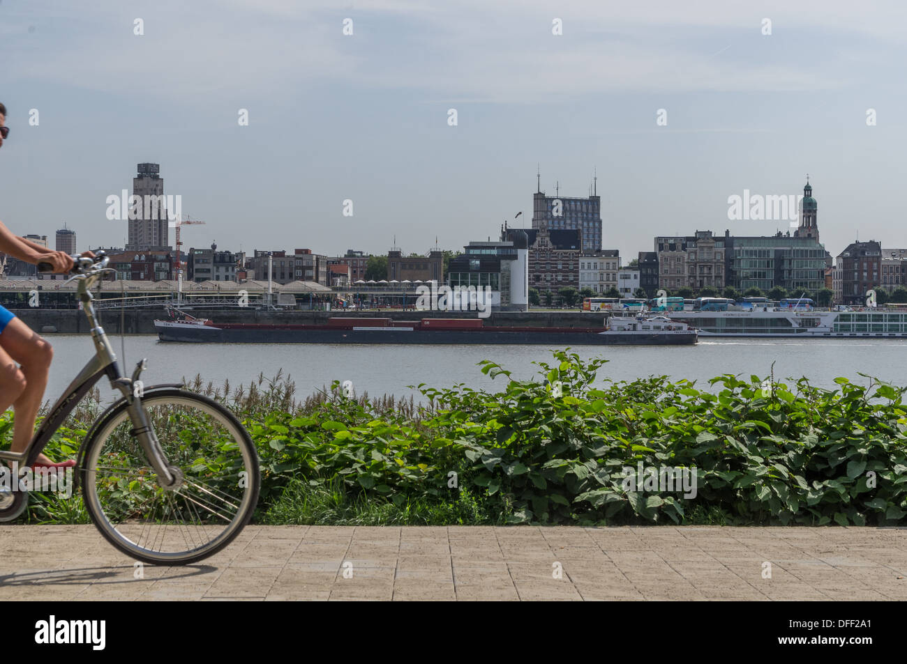 Una chiatta sul fiume, un ciclista a fianco - un trasporto ecologico ad Anversa, in Belgio Foto Stock