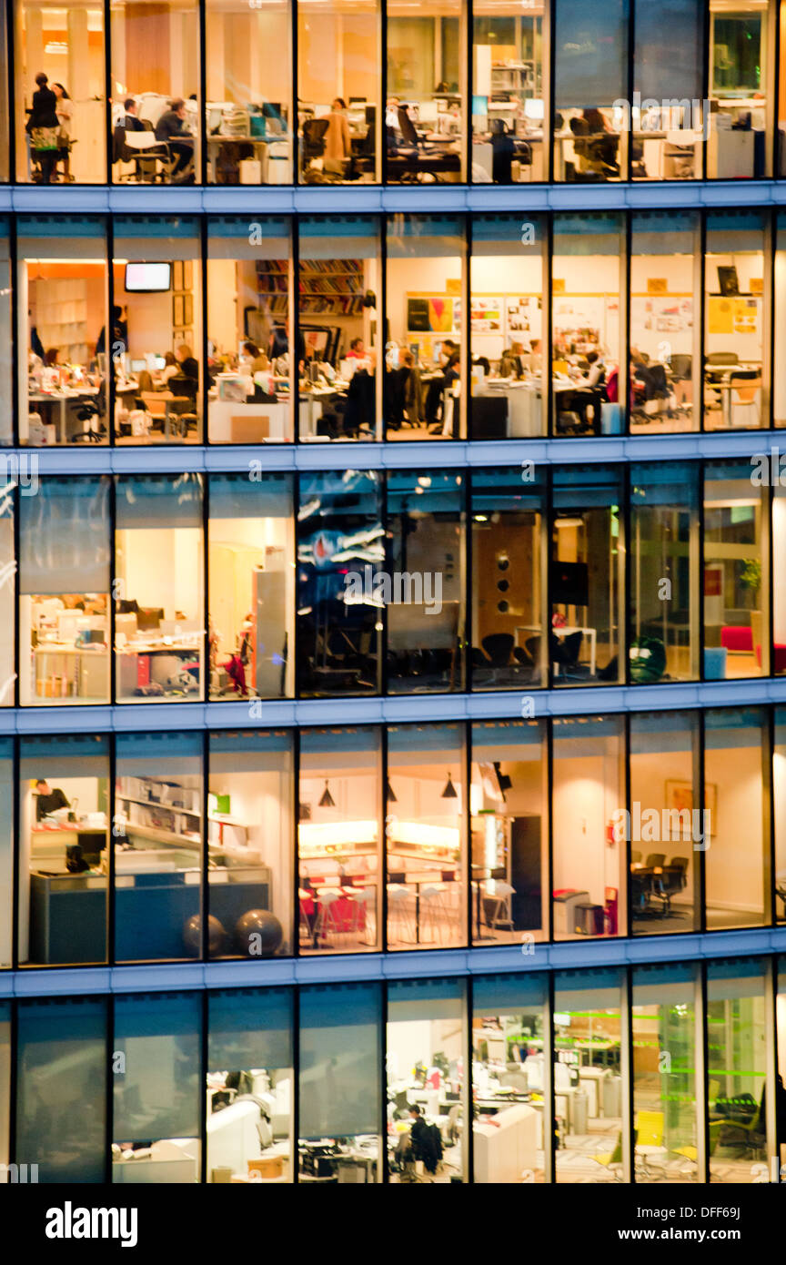 London, Regno Unito - Febbraio 2013: le persone a lavorare in un ufficio moderno edificio al crepuscolo. Foto Stock
