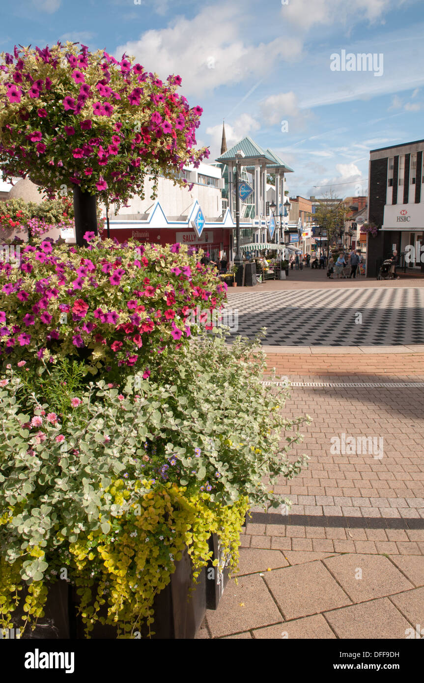 Vista sul centro di Halesowen e sul Cornbow Shopping Centre, nelle West Midlands con una bancarella di fiori estivi in una scena di strada Foto Stock