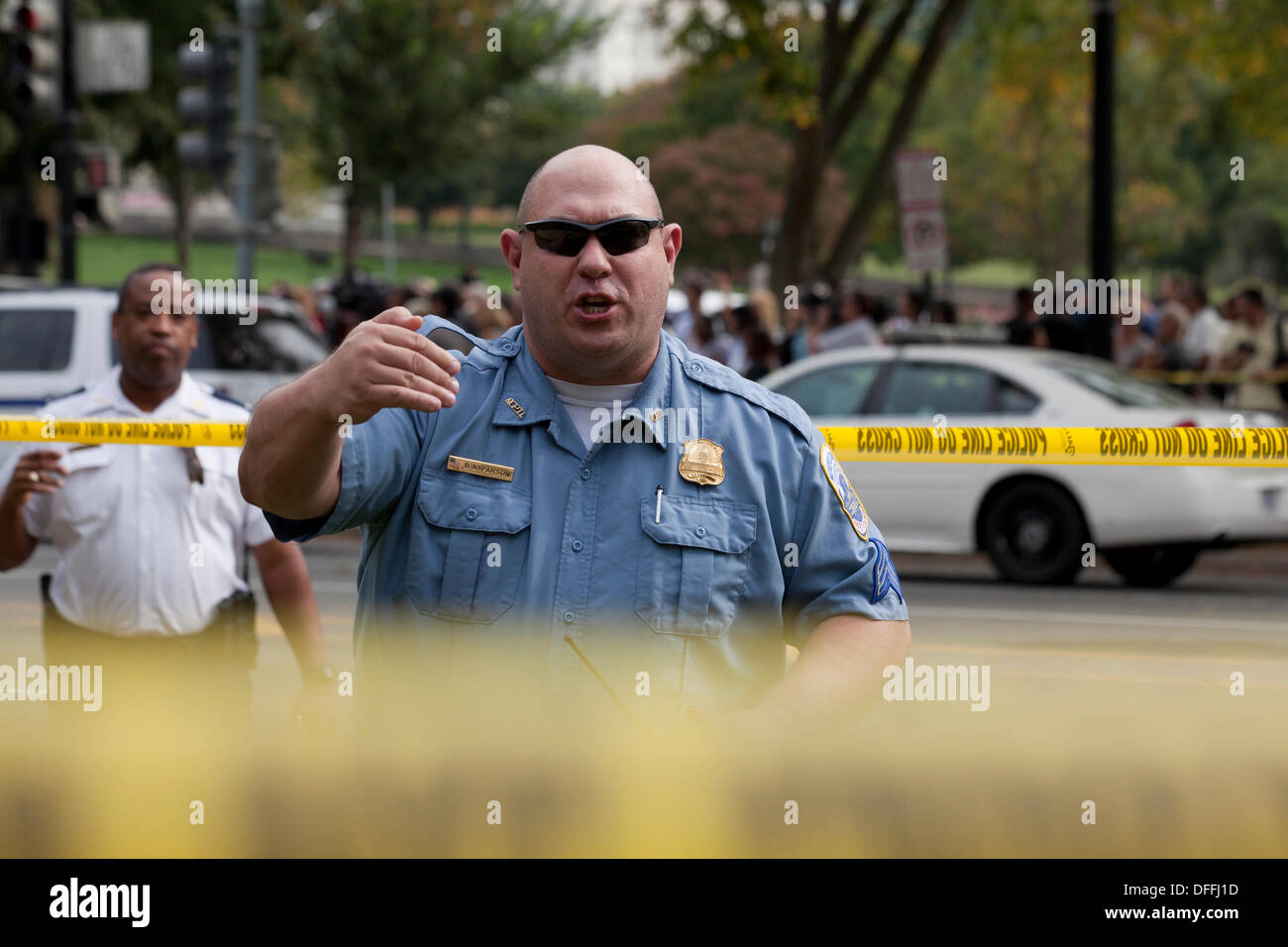 Poliziotto spingendo indietro la folla a scena del crimine - Washington DC, Stati Uniti d'America Foto Stock