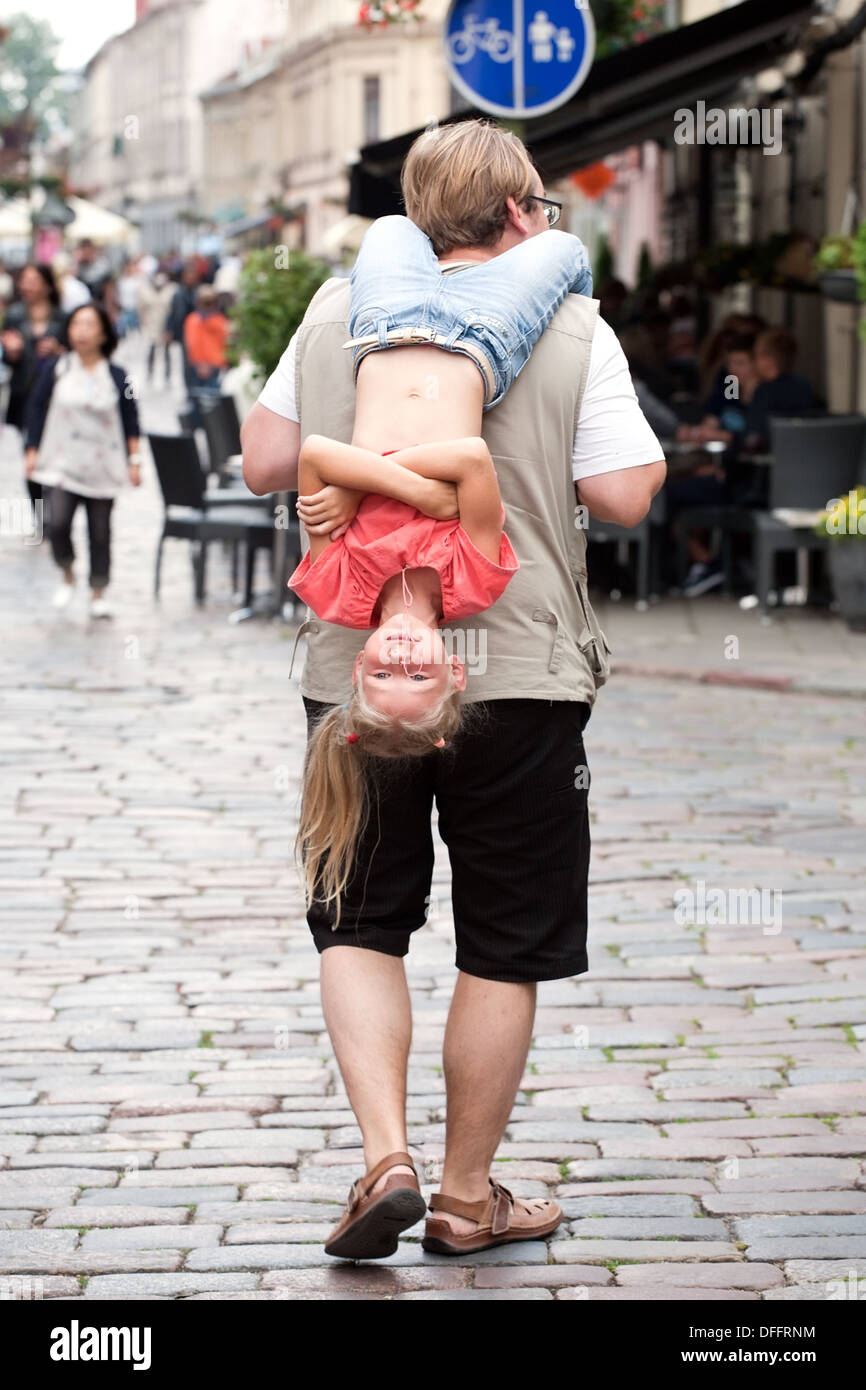 Uomo che porta sulle sue spalle divertente bambina Foto Stock