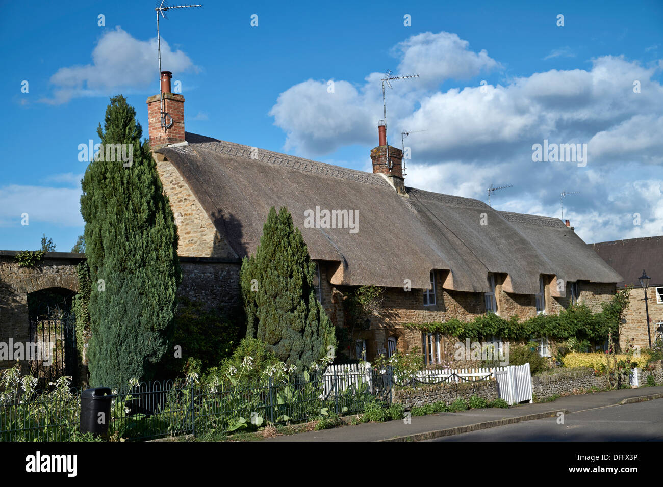 Cottage con tetto in paglia Regno Unito. Pittoresca fila di cottage in pietra di Cotswold con tetto di paglia adornato da Norfolk Reed. Kings Sutton, Banbury, Oxfordshire Foto Stock