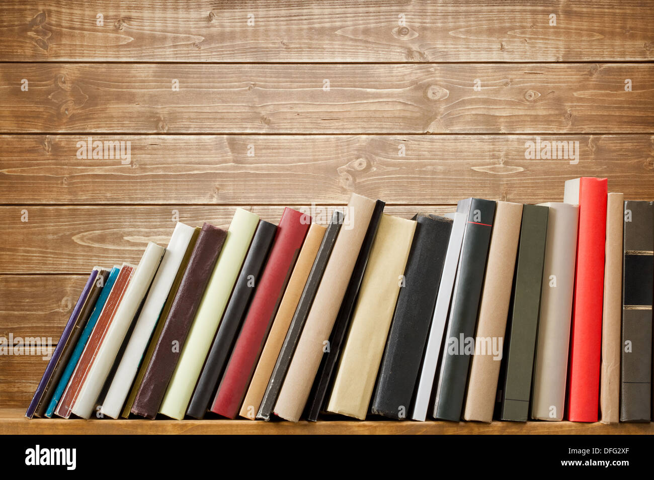 Vecchi libri su uno scaffale di legno. Nessuna etichetta, vuoto della colonna vertebrale. Foto Stock