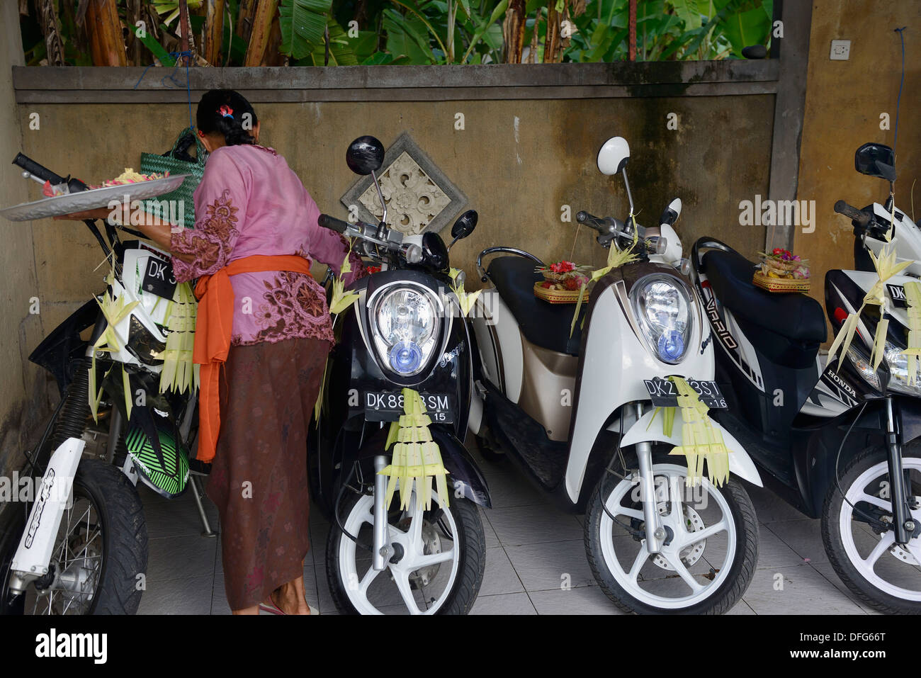 Indonesia, isola di Bali, Amed village, il giorno della cerimonia donna benedizione del motociclo Foto Stock