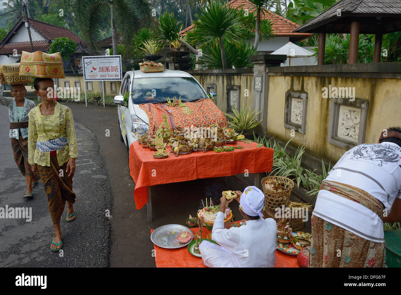 Indonesia, isola di Bali, Amed village, il giorno della cerimonia per la benedizione del veicolo, le donne che trasportano le offerte Foto Stock