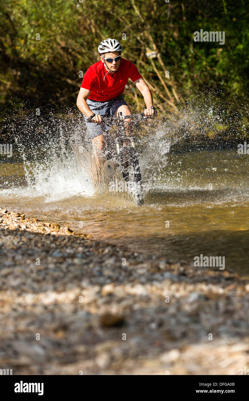 Mountain Biker attraversare un torrente, Winterbach, Baden-Württemberg, Germania Foto Stock