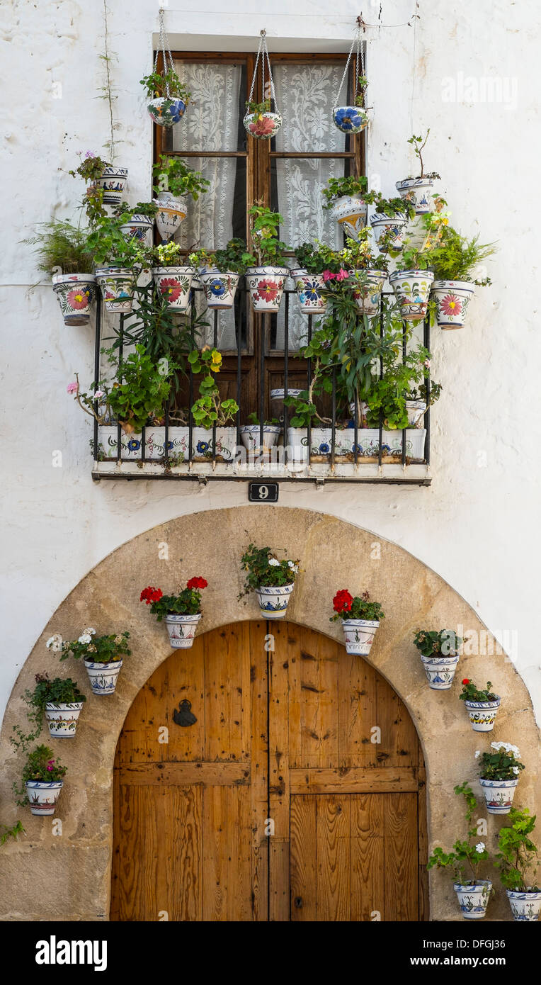 Fiori in vaso adornano un balcone e porta nella Città Vecchia, Javea, Spagna. Foto Stock