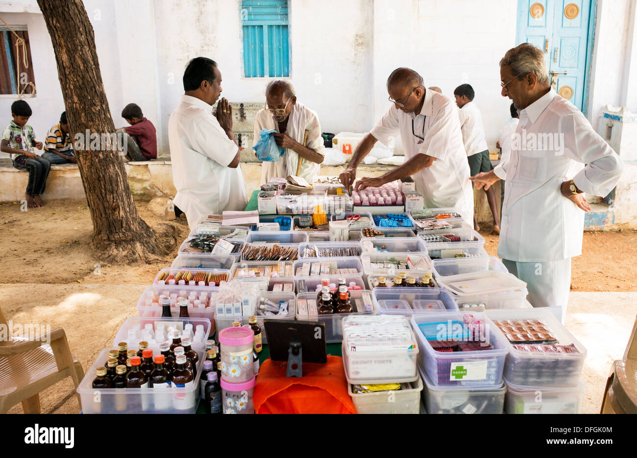 Farmacisti erogazione di farmaci privi di un vecchio uomo al Sri Sathya Sai Baba outreach mobile farmacia ospedaliera. India Foto Stock