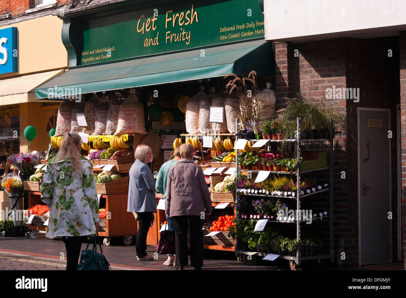 I clienti al di fuori di un fruttivendolo negozio di frutta e verdura Display UK Foto Stock