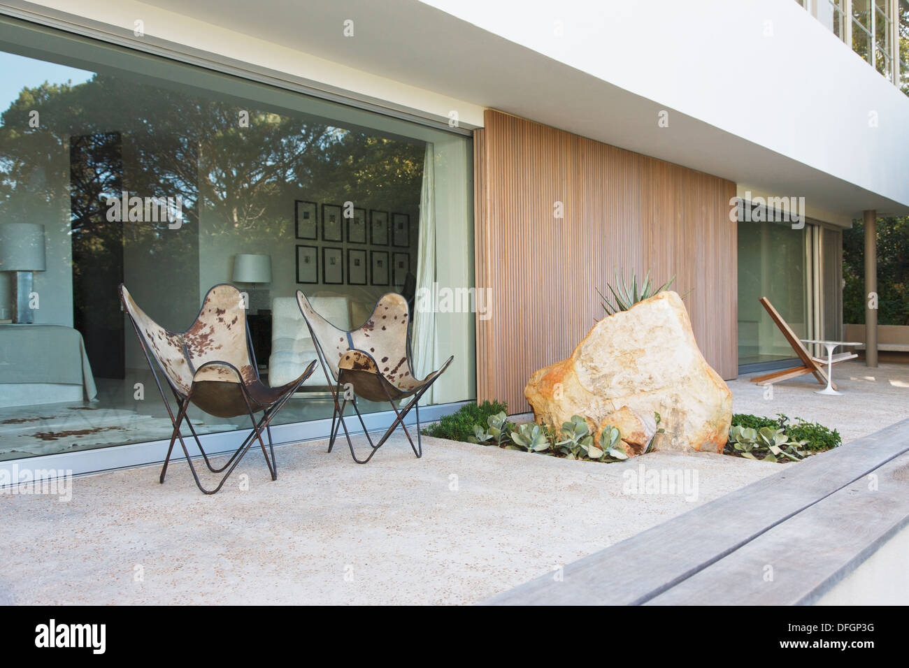 Sedie e boulder sul patio della casa moderna Foto Stock