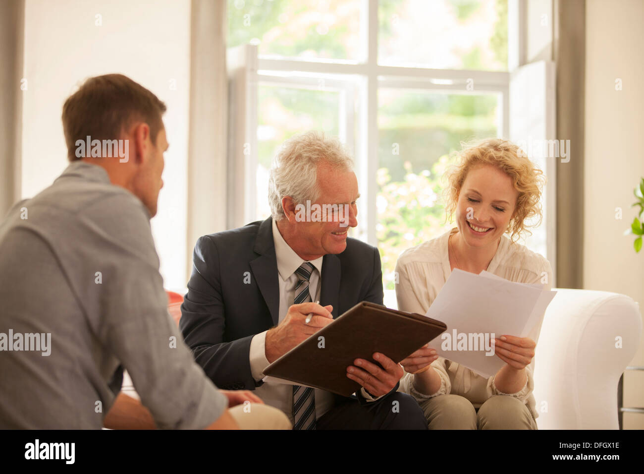 Advisor finanziario di parlare al giovane in salotto Foto Stock