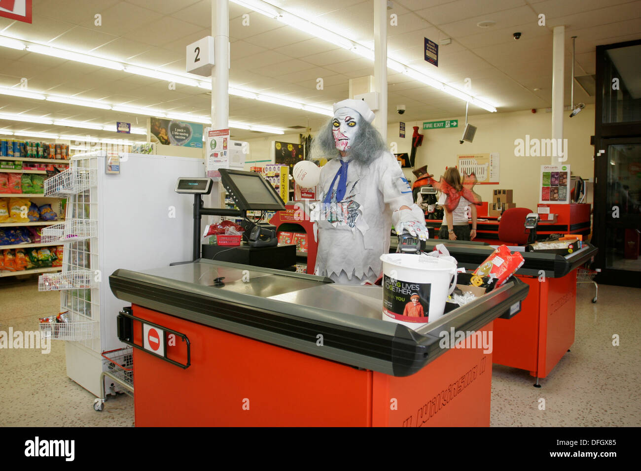 Supermercato cassiere indossando un abito elegante costume per Halloween. Regno Unito Foto Stock