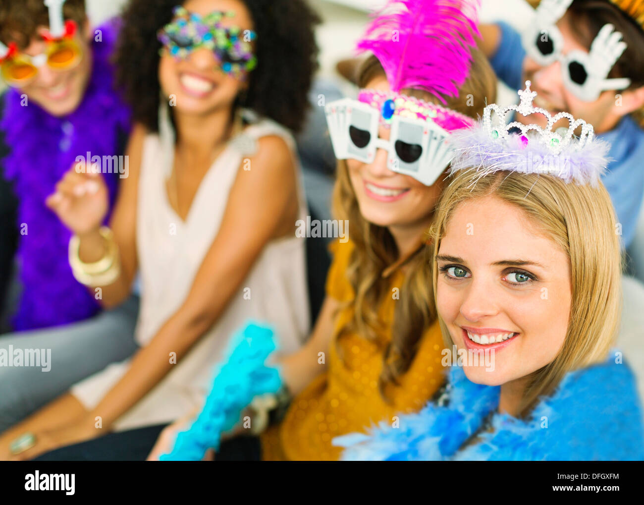 Amici indossando bicchieri decorativi e corone a parte Foto Stock