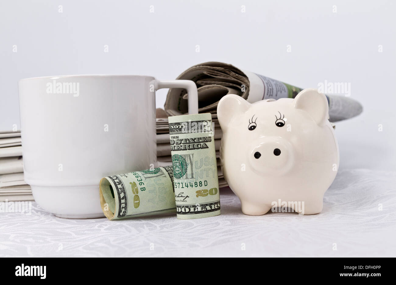 Simboli iconici di valuta degli Stati Uniti, bianco savings bank, quotidiani, e tazza da caffè rappresentano l'economia americana nelle notizie Foto Stock