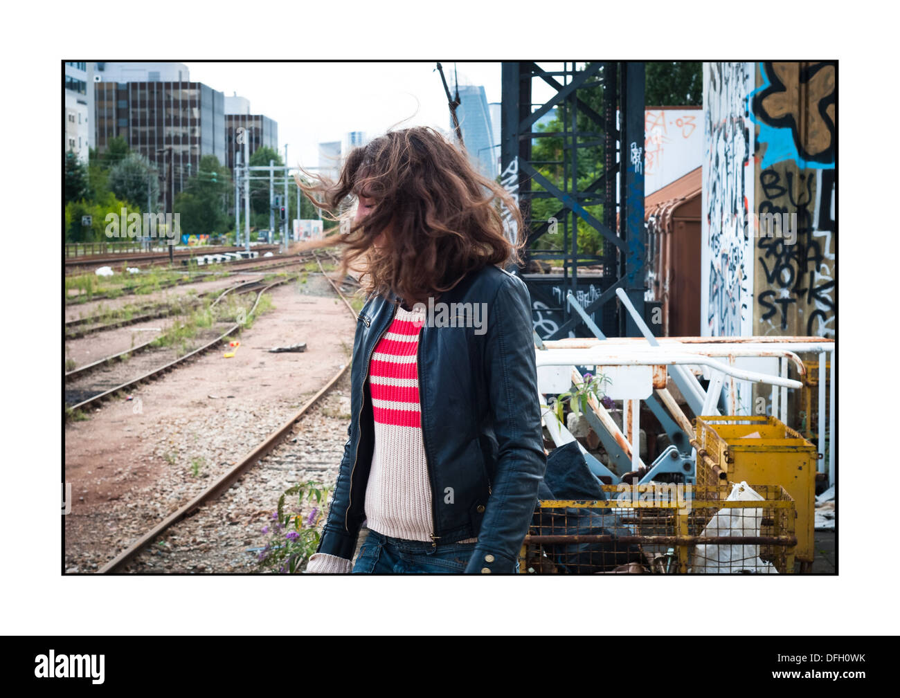 Giovane donna nei pressi di un convoglio ferroviario, su una vecchia stazione ferroviaria SNCF, Courbevoie, Francia. Foto Stock