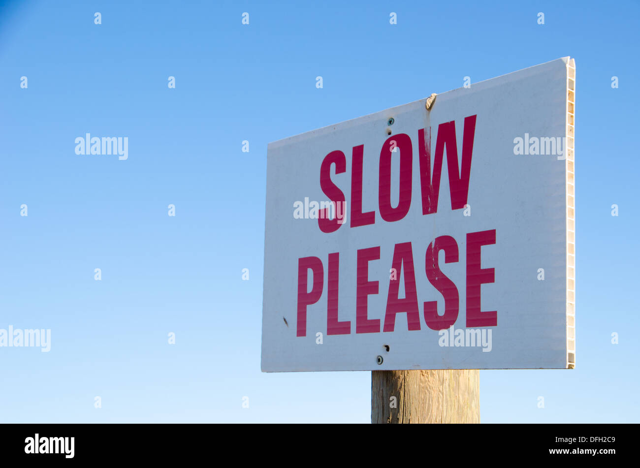 Il bianco e il rosso 'Slow si prega di segno su una strada sterrata in tranquilla e quieta Prince Edward Island, Canada Foto Stock