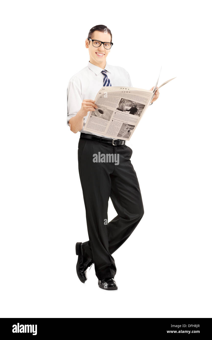 A piena lunghezza Ritratto di un imprenditore sorridente appoggiata contro la parete e tenere un giornale Foto Stock