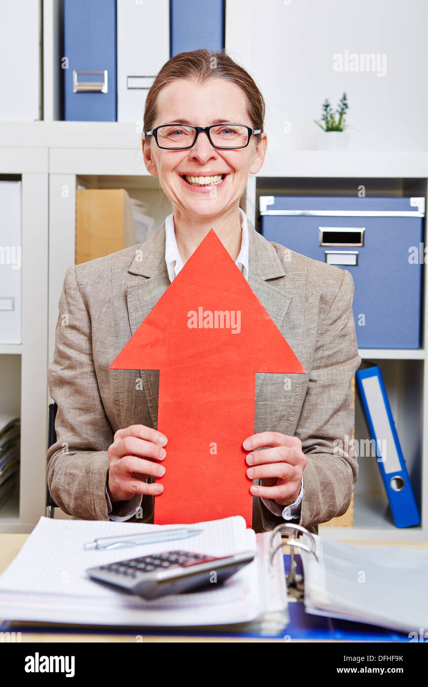 Felice senior business donna tenendo premuto freccia rossa fino in ufficio Foto Stock