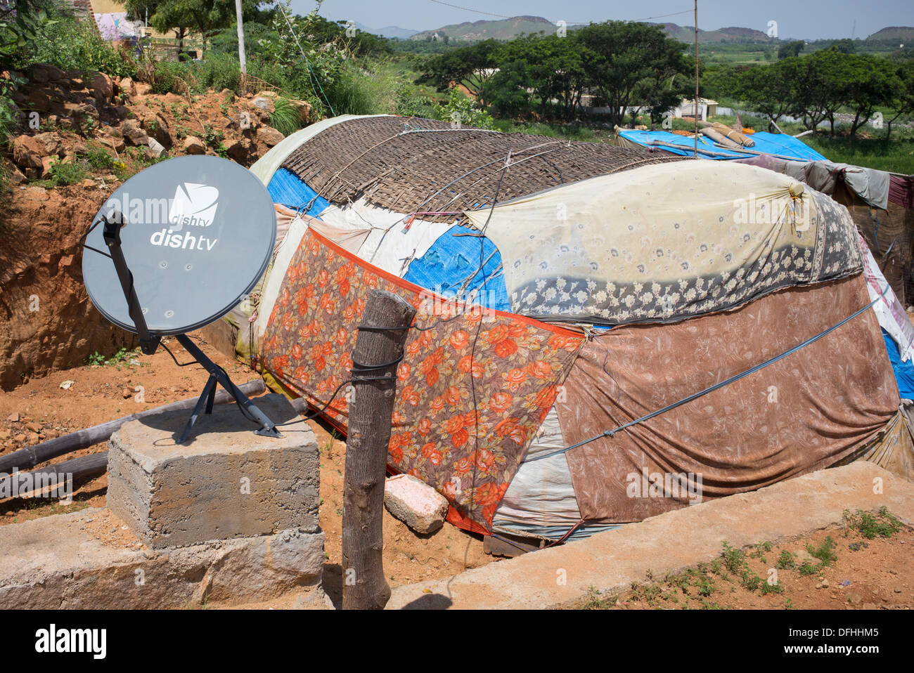 TV satellitare al di fuori di un ambiente rurale di casta inferiore famiglie indiano tenda. Andhra Pradesh, India Foto Stock