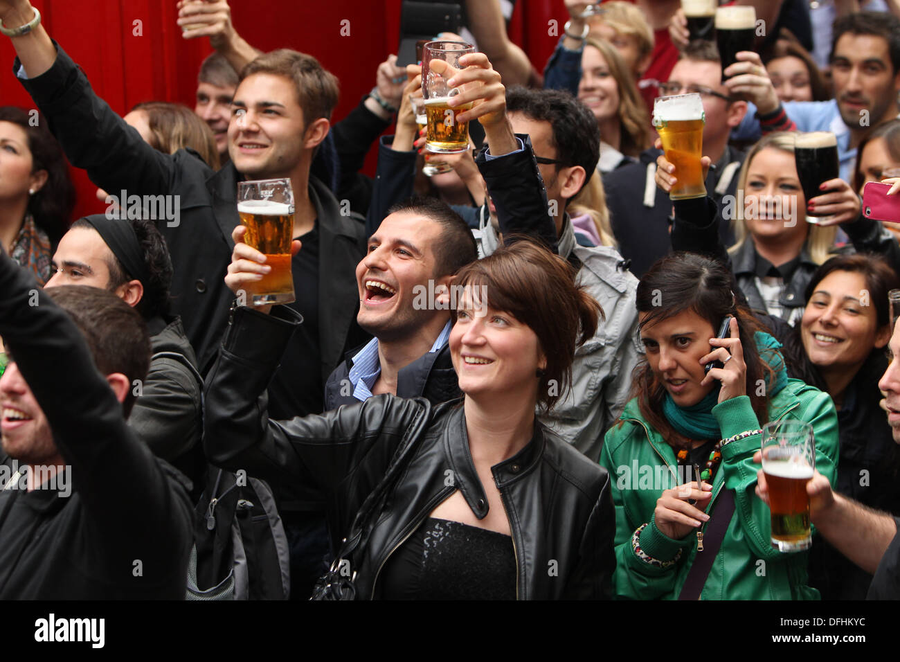 Immagine di una donna in una strada affollata con in mano una pinta di birra durante l'Arthur's celebrazioni del Giorno Dubln nel centro citta'. Foto Stock